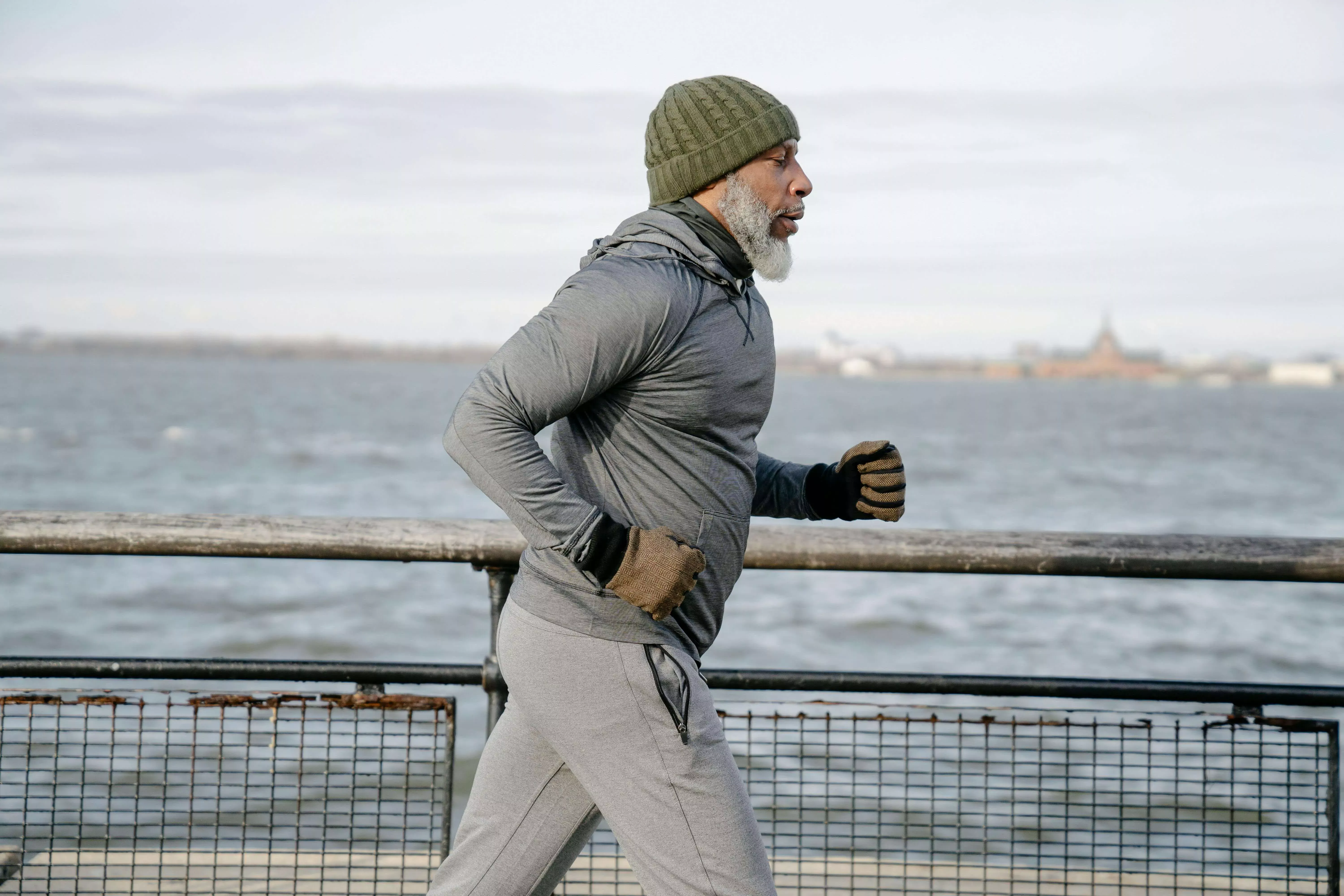 Middle aged man jogging by city seaside